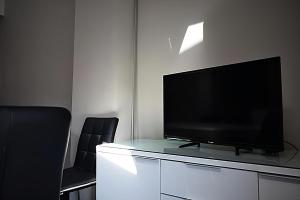 a flat screen tv sitting on a cabinet with two chairs at CASA PETRA in Morella
