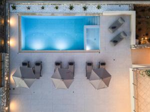 a swimming pool with a bunch of chairs in a room at Villa Arismari in Tria Monastiria