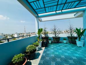 einen Balkon mit Topfpflanzen und Stadtblick in der Unterkunft Khách Sạn Metro Ban Mê in Buon Ma Thuot