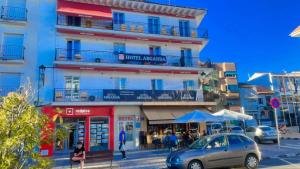 阿尔甘达·德尔·雷伊Hotel Arganda的街道上的建筑物,前面有停车位