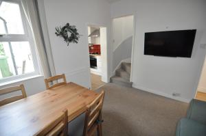 a living room with a table and a television on a wall at Exeter Quay & City Centre St Leonards in Exeter