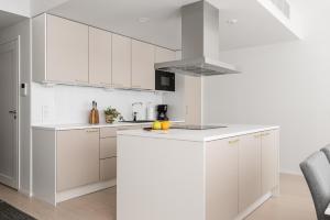 a white kitchen with white cabinets and a stove top oven at Borg Katarina - Riverside View in Pori