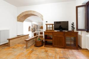 a living room with a flat screen tv on a wooden stand at Chalet nella roccia da Marinella in Taceno