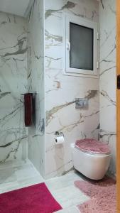 baño con bañera y TV en la pared en Hammamet appart with pool, en Nabeul