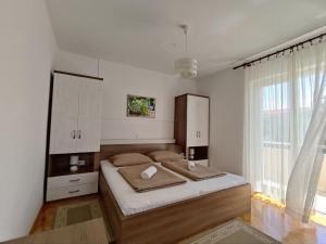a bedroom with a large bed and a large window at Apartmani Katarina&Ivan Krstinić in Rab