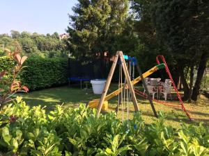 um parque infantil num quintal com jardim em Albergo Cristallo em Cittiglio