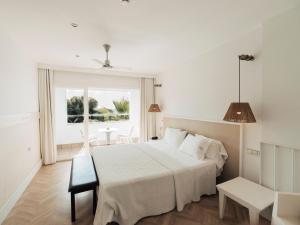 a bedroom with a large white bed and a window at Hotel MC San José in San José