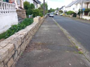 a stone retaining wall next to a street at Chambre dans maison individuelle avec rez-de-chaussée partagé - cuisine, salle, salon et salle de bains in Saint-Brieuc