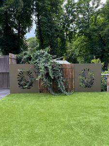 a garden with a fence with green grass at The One Apartments in Siófok