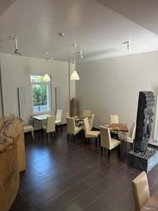 a dining room with tables and chairs and a fireplace at The One Apartments in Siófok