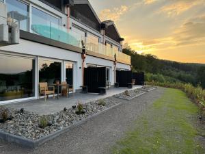 a building with a patio with a table and chairs at Ommi Kese See-Suite Sauna Biggesee in Olpe