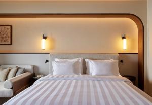 a bedroom with a bed with two pillows and a couch at Daios Cove in Agios Nikolaos