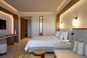 a hotel room with a bed and a couch at Daios Cove in Agios Nikolaos