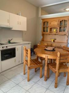 a kitchen with a wooden table and chairs in it at Casa di Stephanie - Petrothalassa - Porto Heli in Kranidi
