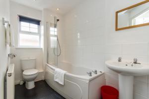 a white bathroom with a sink and a tub and a toilet at Sawadee Apartments in Warwick +31 photos