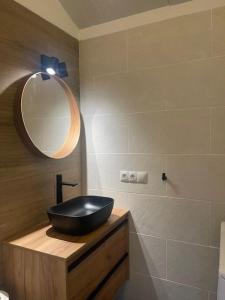 ein Badezimmer mit einem schwarzen Waschbecken und einem Spiegel in der Unterkunft Luxury Bungalow Sonnenland in Sonnenland