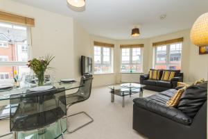 a living room with a glass table and a couch at Sawadee Apartments in Warwick