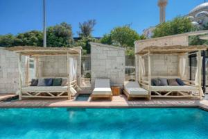 a swimming pool with two beds and a swimming pool at Ayayorgi Homes in Çeşme
