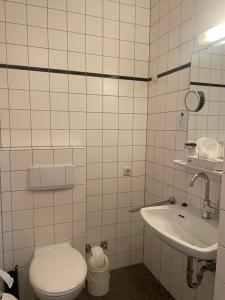 a bathroom with a toilet and a sink at Hotel Corsten in Heinsberg
