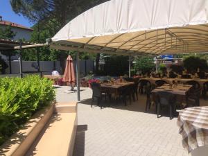a restaurant with tables and chairs under a canopy at Albergo Cristallo in Cittiglio +7 photos