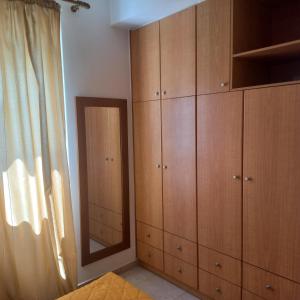 a bedroom with wooden cabinets and a mirror at Central Rooms in Makry Gialos