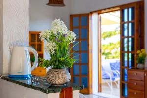 a vase with flowers sitting on a counter with a kitchen at Nice to stay in Fontane Bianche