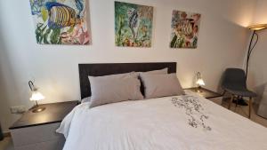 a bedroom with a bed and three paintings on the wall at Carousel Apartments in Qrendi +84 photos