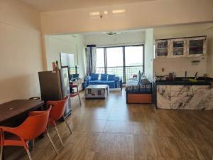 a living room with a kitchen and a living room with a couch at Ratnaparkhi's Villa in Dapoli
