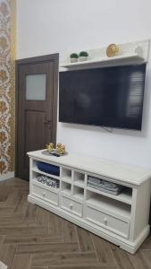 a white entertainment center with a tv on a wall at APARTAMENT JARACZA 28 Nr 3 in Słupsk
