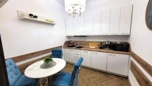 a kitchen with white cabinets and a table and chairs at APARTAMENT JARACZA 28 Nr 3 in Słupsk