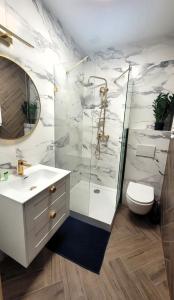 a bathroom with a shower and a sink and a toilet at APARTAMENT JARACZA 28 Nr 3 in Słupsk +13 photos