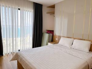 une chambre avec un grand lit et une grande fenêtre dans l'établissement BBnB Home - Mai's House, à Quy Nhơn 24 autres photos