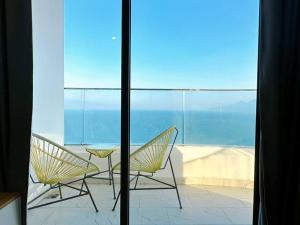 deux chaises et une table sur un balcon avec l'océan dans l'établissement BBnB Home - Mai's House, à Quy Nhơn