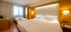 a hotel room with a large white bed and a window at Abba Rambla Hotel in Barcelona