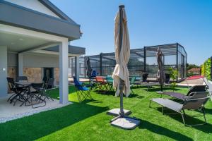 a patio with chairs and umbrellas on the grass at Porto Vivenda em Lever-casa inteira in Lever