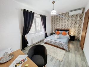 a small bedroom with a bed and a table at Cazare Pensiune La Bozi in Utvin