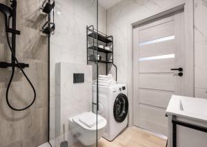 Un baño con inodoro y lavadora. en Nowodwory Cosy Apartment by BookingHost, en Varsovia 17 fotos más