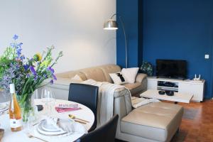 a living room with a couch and a table at Sunny Apartment - Zuid Retreat 1BR Apartment near Scheldt River in Antwerp