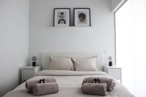 a white bedroom with a bed with two towels on it at Sunny Apartment - Zuid Retreat 1BR Apartment near Scheldt River in Antwerp