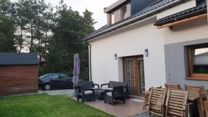a patio with chairs and an umbrella and a car at Lusowo DOM in Lusowo