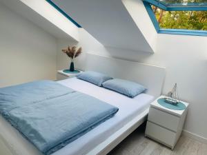 een witte slaapkamer met een bed en een raam bij Apartament DWIE RYBKI in Pobierowo