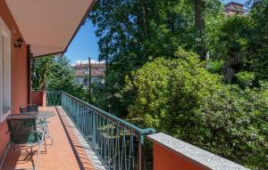a balcony with a table and chairs and trees at 2 Bedroom Beautiful Apartment In Stresa in Stresa