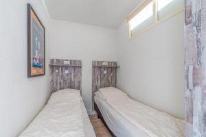 Dos camas en una habitación pequeña con ventana. en Appartementencomplex Juliana 138, en De Koog 5 fotos más