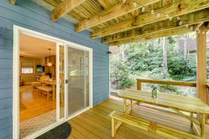 una veranda protetta con una panchina su una casa blu di Creek View and Hot Tub Woodsy Maggie Valley Cottage a Maggie Valley