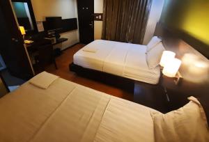 Postel nebo postele na pokoji v ubytování Lorenzzo Suites Hotel Makati
