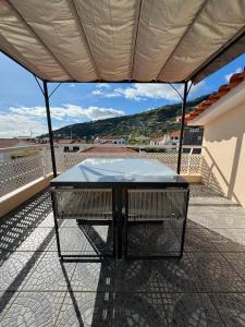 una mesa en el balcón de una casa en Arco Apartment, en Arco da Calheta