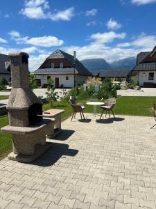 a patio with a fireplace and a table and chairs at TATRYSTAY Family Villa Rosa in Stará Lesná