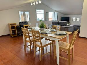 a dining table and chairs in a living room at Arco Apartment in Arco da Calheta