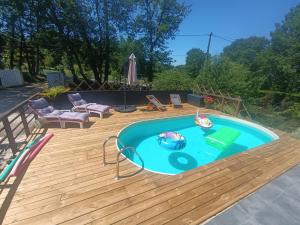 a swimming pool on a wooden deck with a wooden deck at Maison a la campagne in Biras
