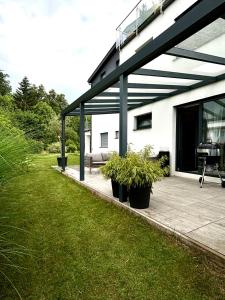a patio with potted plants on the side of a house at Schöne Wohnung mit Terrasse und Parkplatz in Velden am Wörthersee